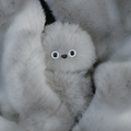 Mirumi bag charm robot in Gray. Features soft, muted gray fluffy fur and two small eyes.