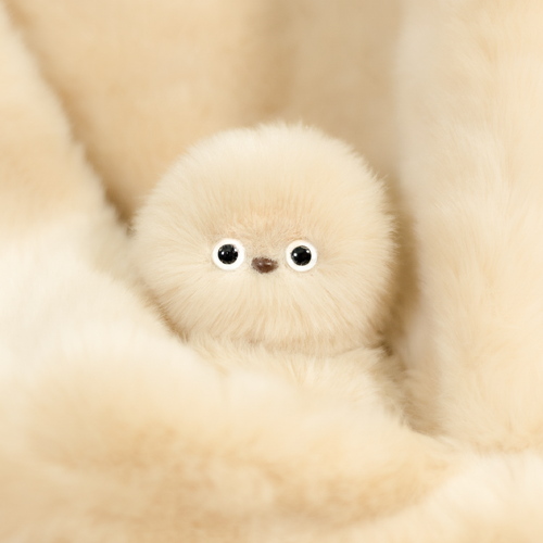 Mirumi bag charm robot in Ivory. Features warm, light beige fluffy fur and two small eyes.